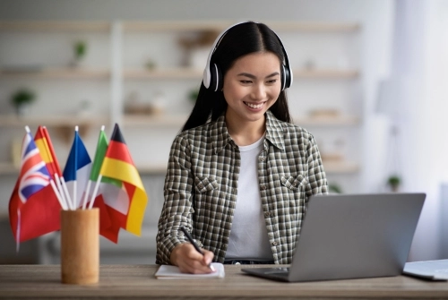 A female explores how to learn a new language by exploring language programs on her laptop. jn